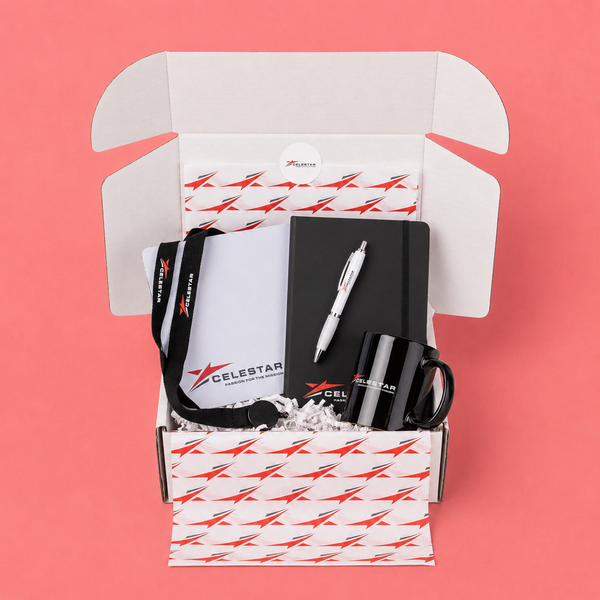 Swag Box with stationery items including a notebook, pen, and mug on a pink background