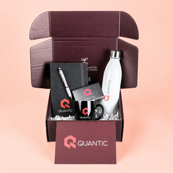 Gift box with Quantic branded items on a pink background