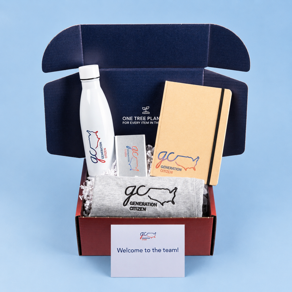 Swag box with branded items including a water bottle, notebook, and towel on a blue background.